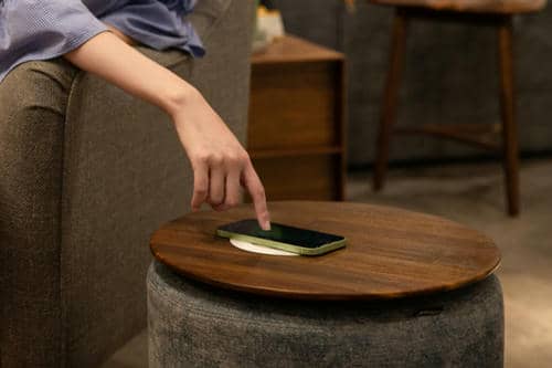 smartphone en charge à induction sur table de salon